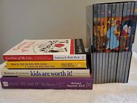 Stack showing four parenting paperbacks and spines of Disney boxed set