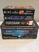 Stack of six John Grisham books showing titles and formats