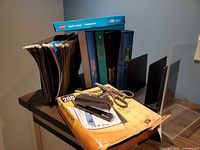 Group shot showing binders, file folders, magazine holders, stapler, scissors and sheet protector package