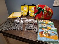 All items grouped: flatware, Peanuts mitts, yellow potholders, tea cozy, moose potholders