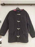 Front view of black hooded duffle coat with toggle closures and pockets