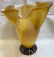 Full view of amber glass vase showing ruffled rim and foot