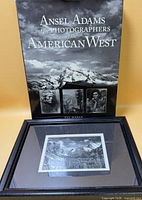Book standing behind framed print showing both items