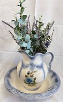 Pitcher in basin with floral arrangement
