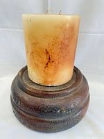 wax candle on ceramic base, front view