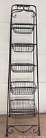 Front view of black metal 5-tier storage rack with wire baskets installed