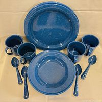 Entire 16-piece blue speckled enamelware set laid out