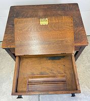 Top view showing hinged lid open, interior storage, front drawer, tiger oak grain, wooden knobs