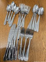 Assorted Cambridge stainless flatware laid out showing quantity and pattern