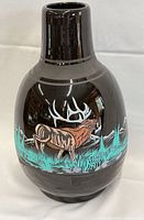 Front of glossy black ceramic vase with painted elk scene