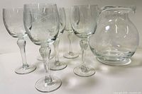 Group view of six etched wine glasses and matching vase