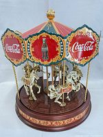 Front angle of Coca-Cola musical carousel showing horses, logo panels, base