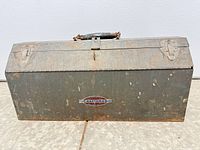 Closed Craftsman metal toolbox front view showing badge, latches and handle