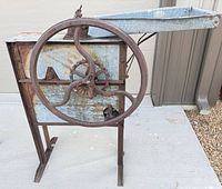 Full view of corn sheller showing flywheel, hopper and stand