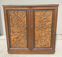 Front view showing twin carved doors and overall form