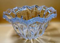 Oblique view of entire cut crystal bowl showing scalloped rim and faceted sides