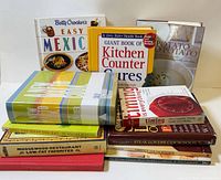 Group shot of all 11 cookbooks standing and stacked