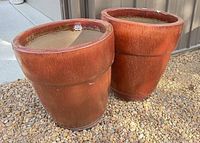Both large red glazed ceramic planters side by side showing exterior surfaces