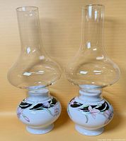 Front view of both hurricane lamps showing bases and chimneys