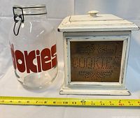 Glass jar and wooden cookie box side by side with measuring tape