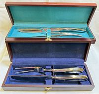 Open cases showing both carving sets; upper case contains three Saladmaster pieces, lower case contains two Hampton Silversmiths pieces