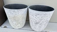 Two round tapered faux-stone planters side by side showing exterior finish
