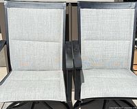 Front view of two chairs showing mesh seats, armrests and general condition