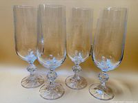 Front view of four etched crystal flutes standing upright