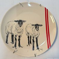 ceramic plate with two sheep, red stripes and hanger clips