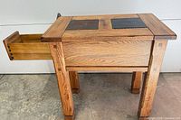 Side view of oak end table with drawer fully extended showing dovetail construction and overall structure