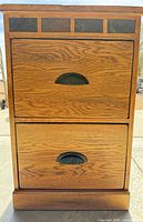 Front view of oak veneer filing cabinet showing two drawers, slate inlay, and metal pulls