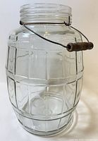 Full view of barrel-shaped glass jar showing bail handle and paneled sides