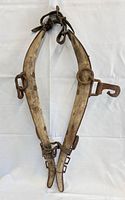 Full view of wooden horse collar harness with iron hardware