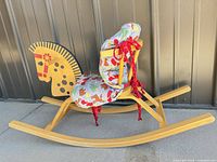 side view rocking horse showing wood frame and fabric cushion