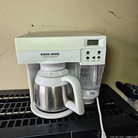 Front view showing coffee maker, digital panel, carafe, reservoir