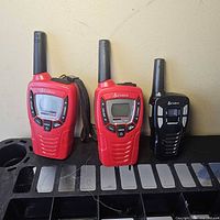 Front view of three Cobra microTALK radios showing screens and controls