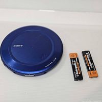 Top view of blue Sony CD Walkman with two Sony NH-14WM(A) batteries