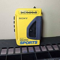 Front view of yellow Sony Walkman Sports WM-AF54 showing logo, tuner band markings, grip