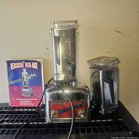 Full view of blender base, tall container, extra jar, manual