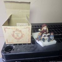 Figurine on foam beside open original box