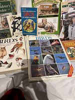 Front view of assorted books laid out showing titles on birds, gardening, catalogue, trees, knitting