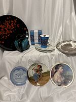 Group shot of all items: platter, pitcher, Taika cup and box, brown plates, three collector plates