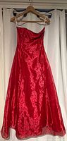 Front view of full-length red gown on hanger