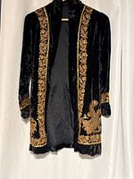 Full view of black velvet jacket showing gold embroidery and lining
