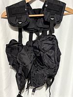 Front view of black tactical vest showing overall structure and attached pouches