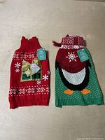 Both dog sweaters laid flat showing front designs
