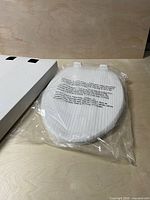 Top view of wrapped elongated toilet seat beside box