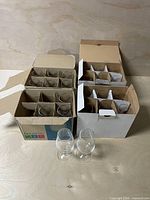 Two boxes containing stemmed tasting glasses with two sample glasses in front