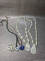 Overview of all five necklaces laid out on fabric