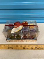 Front view of sealed box showing 12 coloured mini candles in glass holders